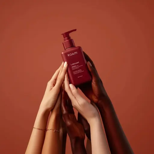 Minimalist product photography of a matte red pump bottle labeled ‘ROAM lubrican...