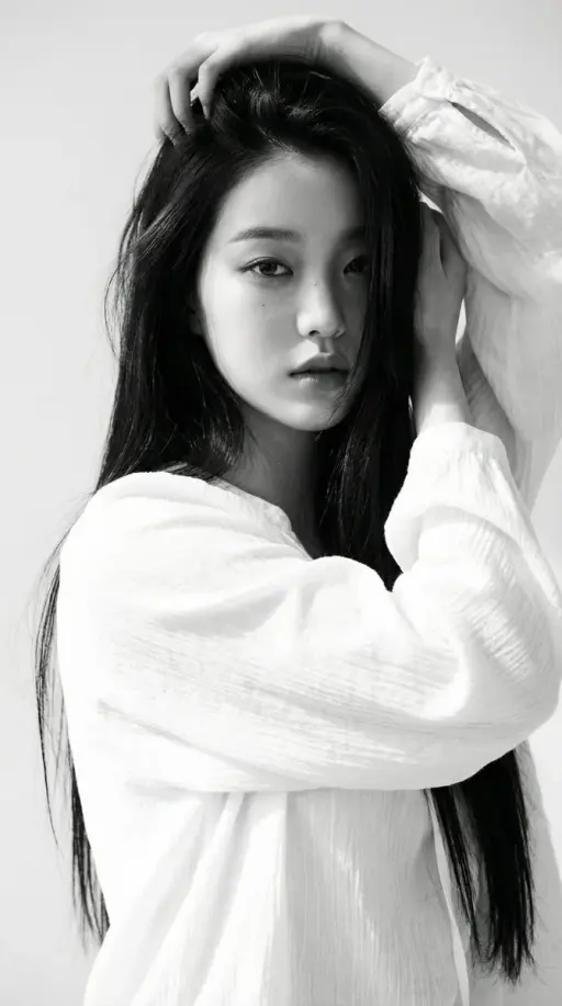 Black-and-white portrait of a young woman with long straight dark hair, wearing...