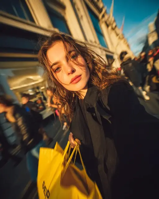 Cinematic street portrait of a young woman walking through a busy shopping stree...